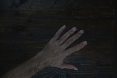 Low section of person hand on wood