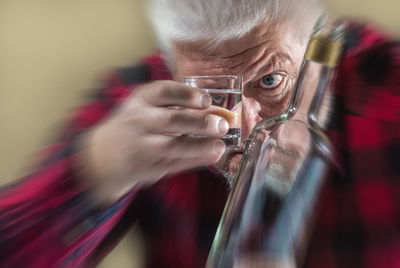 Close-up of man looking through tequila glass