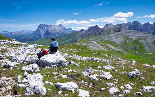 Rear view of man on rock against sky