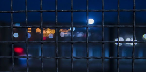 Close-up of metal fence at night