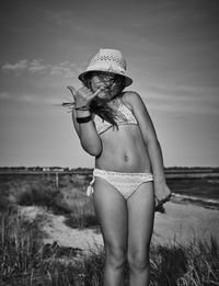 Midsection of woman standing at beach against sky