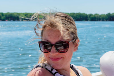 Portrait of woman wearing sunglasses at sea shore