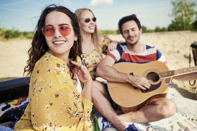 Portrait of a smiling young woman playing guitar