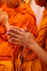 Midsection of man holding orange leaf