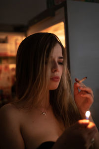 Portrait of young woman holding cigarette