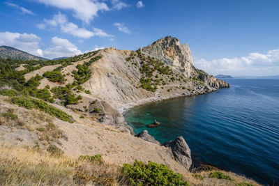 Scenic view of sea and mountains against sky