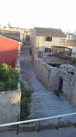 High angle view of buildings by street against sky