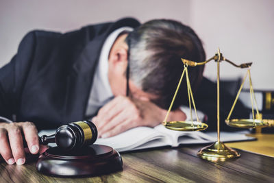 Midsection of man holding camera on table