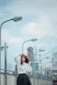 Young woman wearing hat against sky