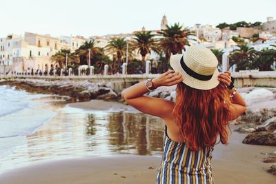 Rear view of woman wearing hat at beach