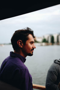 Man looking away against lake