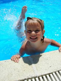 Portrait of smiling cute boy swimming in pool