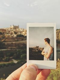 Hand holding the photograph of a man