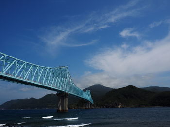Bridge over mountain against blue sky