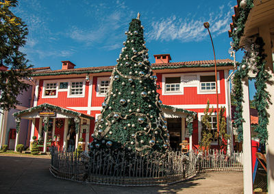 View of christmas tree and wooden house on sunny day in penedo, brazill