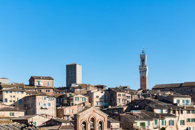 Buildings in city against blue sky