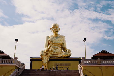 Low angle view of statue against building against sky