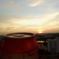 Close-up of red drink against sky at sunset