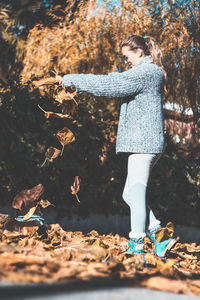 Woman standing in autumn leaves