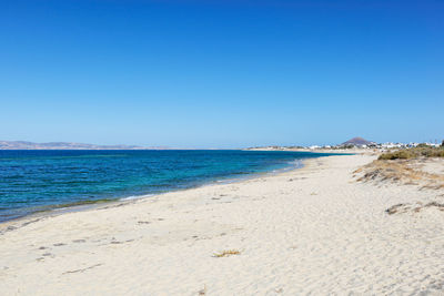 Scenic view of beach against clear blue sky