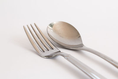 High angle view of spoon in plate against white background