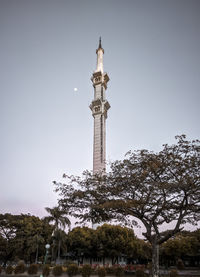 Low angle view of trees and building against sky