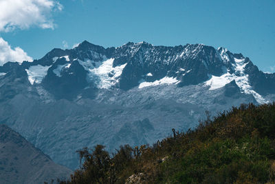 Scenic view of snowcapped mountains against blue sky