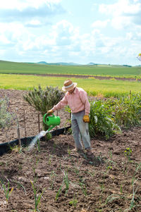 Man working on field against sky