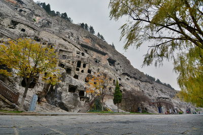 Low angle view of longmen grottoes against sky