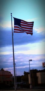 Low angle view of american flag against cloudy sky