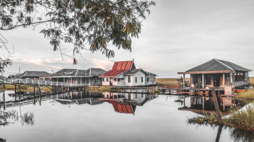 Houses by lake against sky