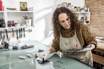 Woman artist preparing ink for an art print. using an ink stick