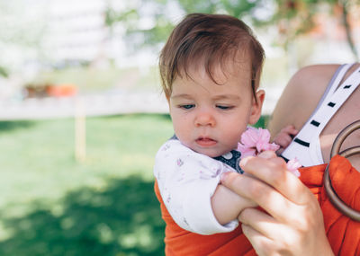 Midsection of woman holding daughter in park