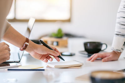 Midsection of business people working on table