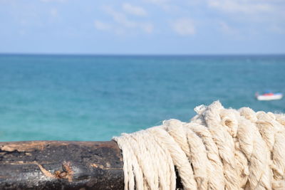 Close-up of rope on beach against sky