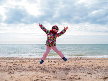 Full length of boy on beach against sky