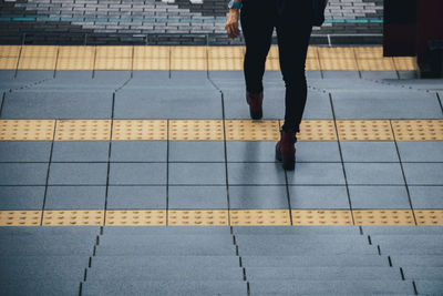 Low section of woman walking on footpath