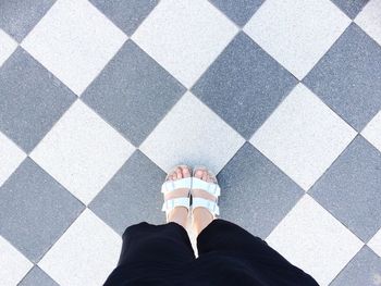 Low section of people standing on tiled floor