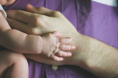 Close-up of adult hand and baby