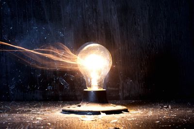 Blurred motion of illuminated light bulb exploding at night