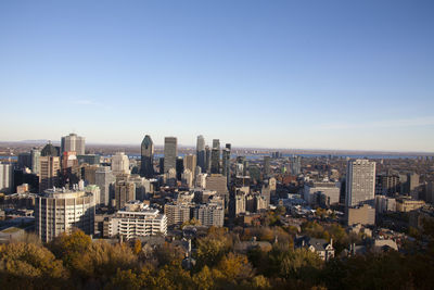 Aerial view of buildings in city against clear sky