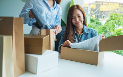 Smiling woman opening parcel box