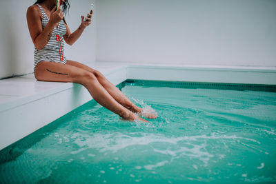 Woman in swimming pool against sea