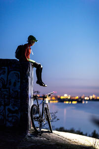 Cyclist sitting on wall