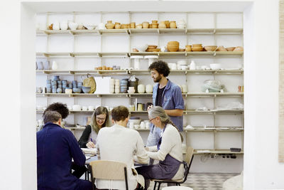 Men and women learning pottery in art studio