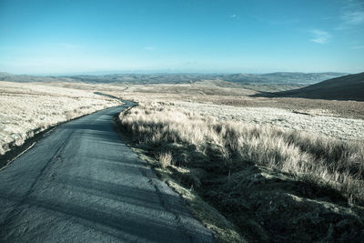 Road passing through landscape against sky