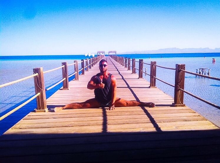 WOMAN SITTING ON PIER