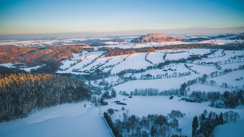 Aerial view of snow covered landscape against sky