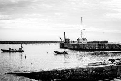 Sailboats moored in harbor