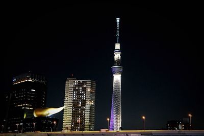 Low angle view of illuminated buildings against sky at night